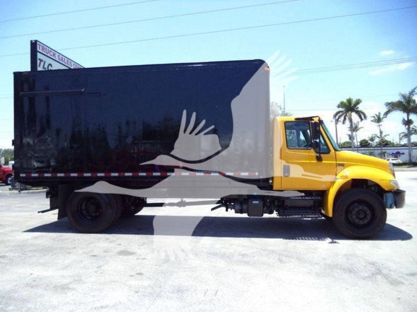 Truck body of 2019 International Durastar 4300 with black cargo box and yellow cab, side view.