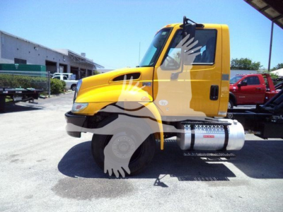 2019 International Durastar 4300 truck side view showing fuel tank and cab; yellow exterior with black grille and side steps.