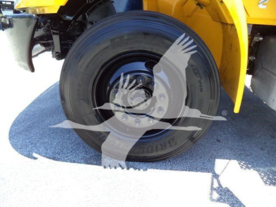 Wheel and tire close-up on a 2019 International Durastar 4300 truck chassis showing the rear tire and part of yellow body.