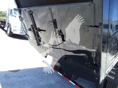 Rear view of a 2019 International Durastar 4300 chipper truck showing rear tailgate with latches and hydraulic mechanism.