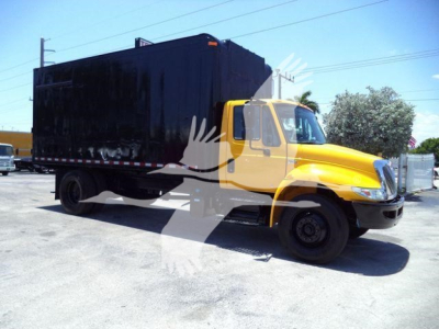 Truck cab and cargo box of a 2019 International Durastar 4300; yellow cab with black enclosed hopper-style body.