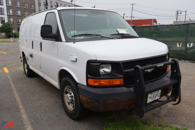White 2005 Chevrolet Express cargo van with front bull bar and side paneling, front grille, headlights, orange turn signal, black bumper, and rust on lower front panel.