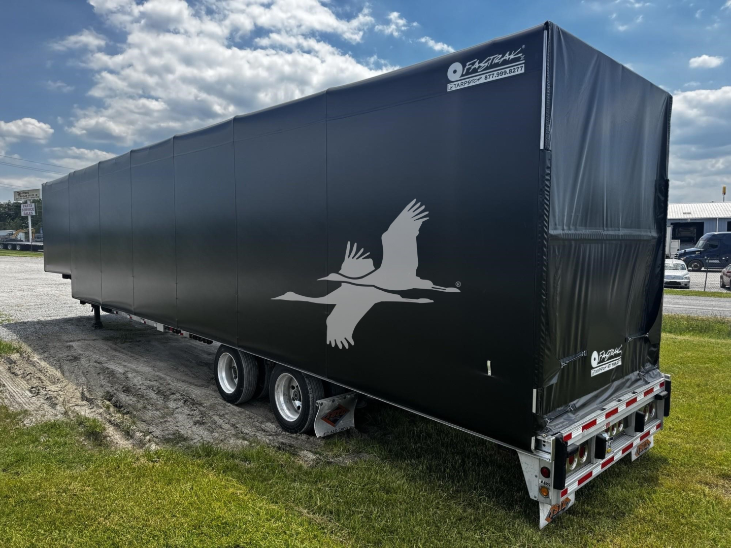 2017 Reitnouer Bubba Drop curtain-side trailer side view showing black tarp with white seagull logo and rear lights.