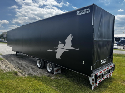 2017 Reitnouer Bubba Drop curtain-side trailer side view showing black tarp with white seagull logo and rear lights.