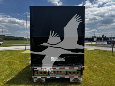 Trailer rear view of a 2017 Reitnouer Bubba Drop curtainside trailer with a black tarpaulin cover featuring a white bird silhouette, lights and license plate visible.