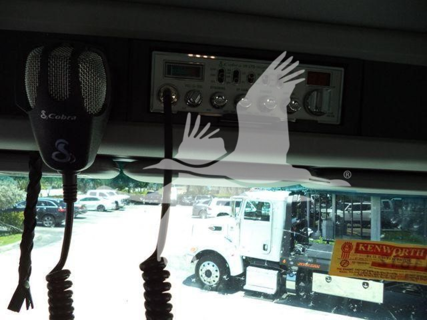 Kenworth T880 truck interior showing CB microphone and control panel with various knobs and meters.