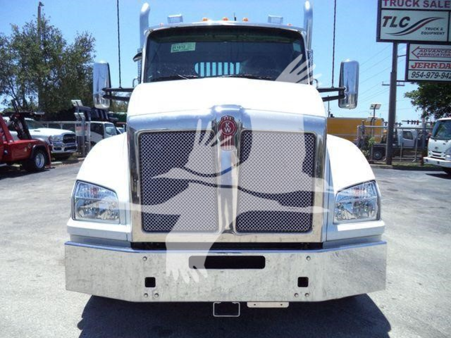 Kenworth T880 front view in white showing grille, bumper, and headlights in a dealership lot.