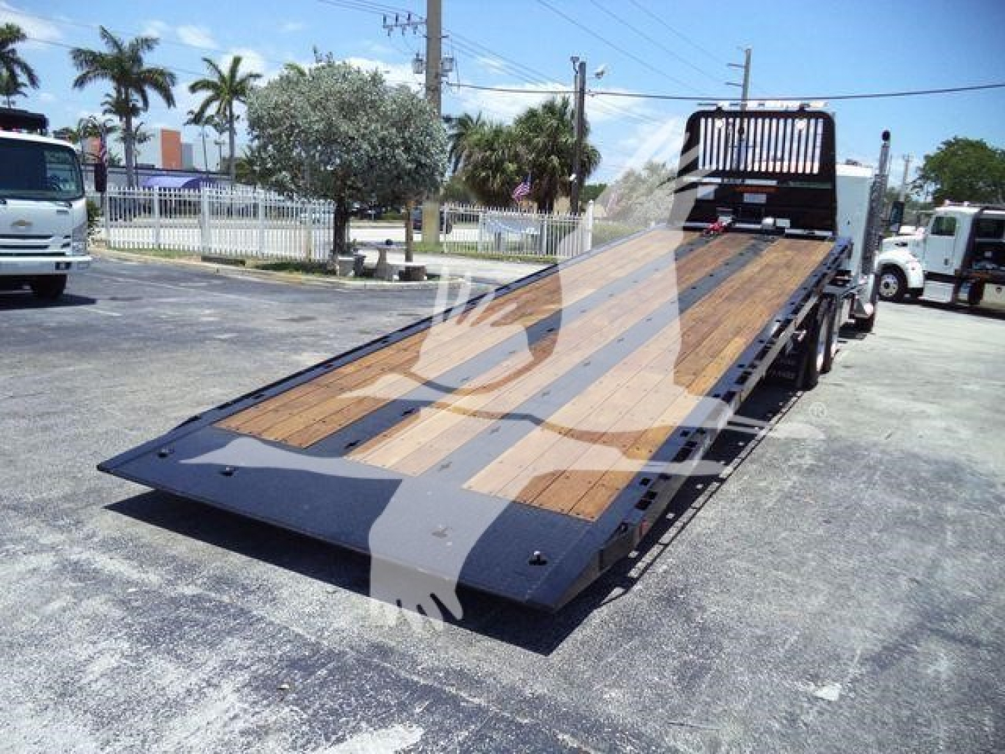 Kenworth T880 rollback bed with wooden deck and ramp, rear view showing loading angle and hydraulic equipment.