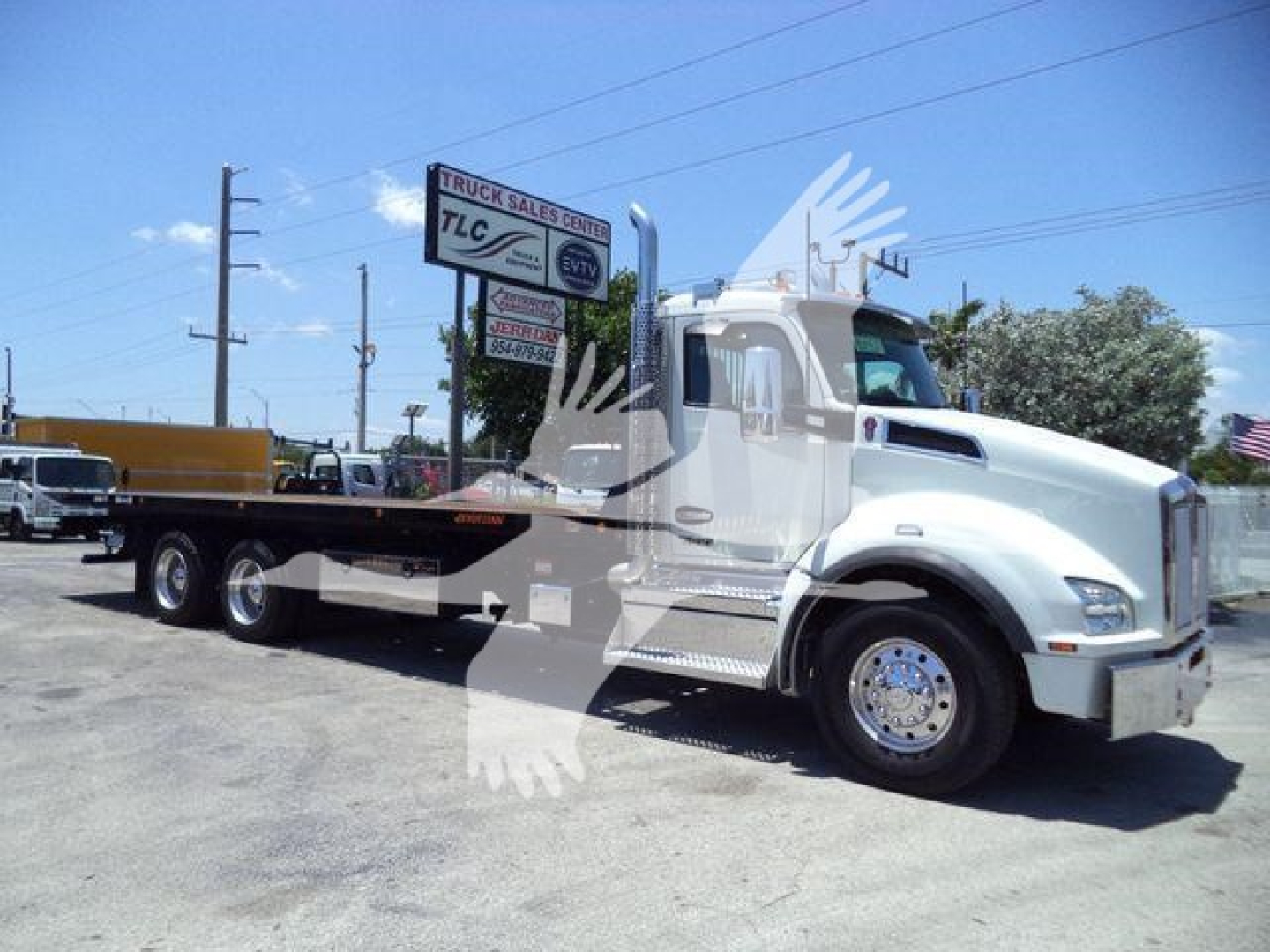 Kenworth T880 tow truck/rollback showing side view with flatbed in a dealership lot.