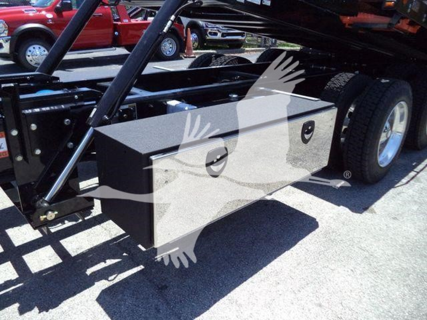 Kenworth T880 rollback truck undercarriage with metal storage toolbox mounted near wheel well.