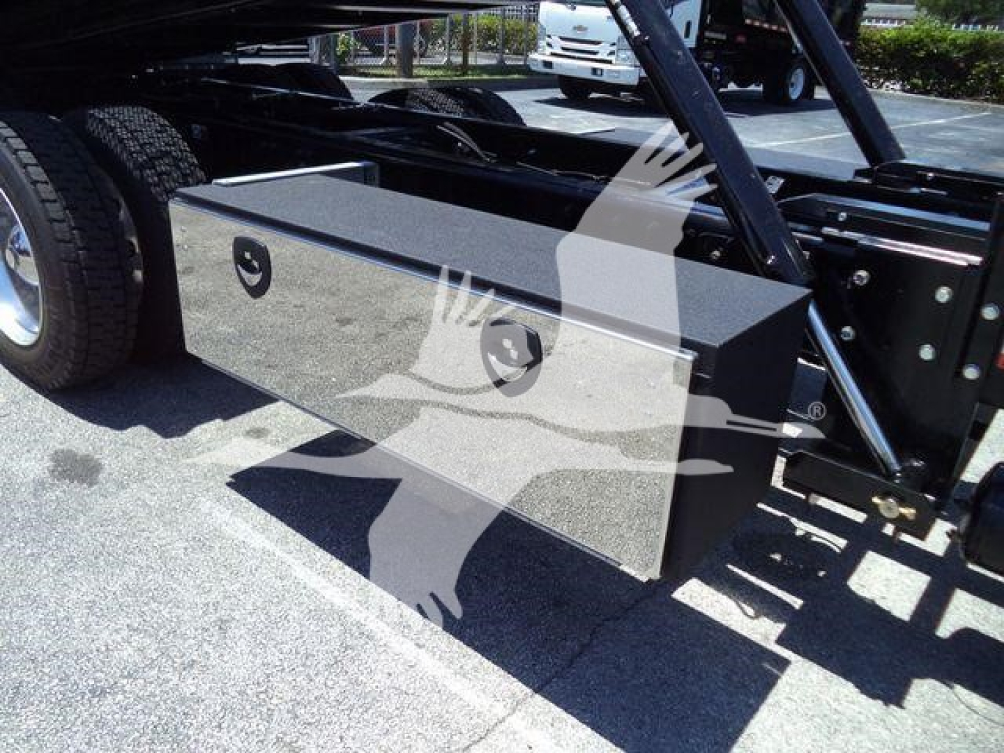 Kenworth T880 rollback truck undercarriage showing a large rectangular metal toolbox with two circular vents and mounting brackets.