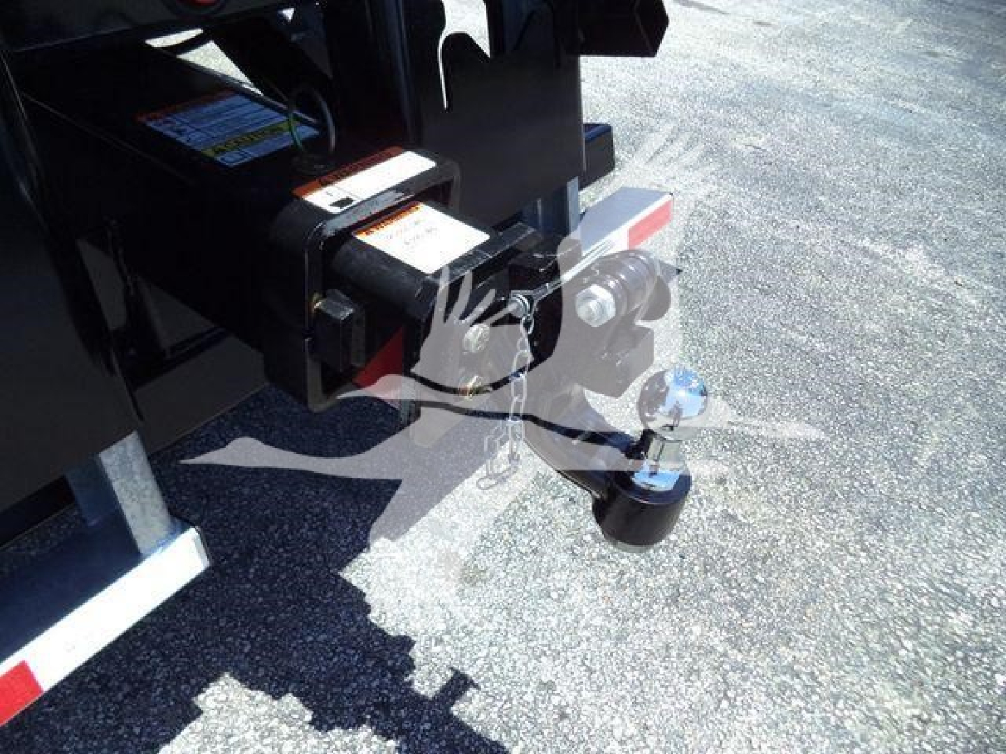 Trailer hitch and pin coupling on a Kenworth T880 setup with visible hitch components and safety chain loop.