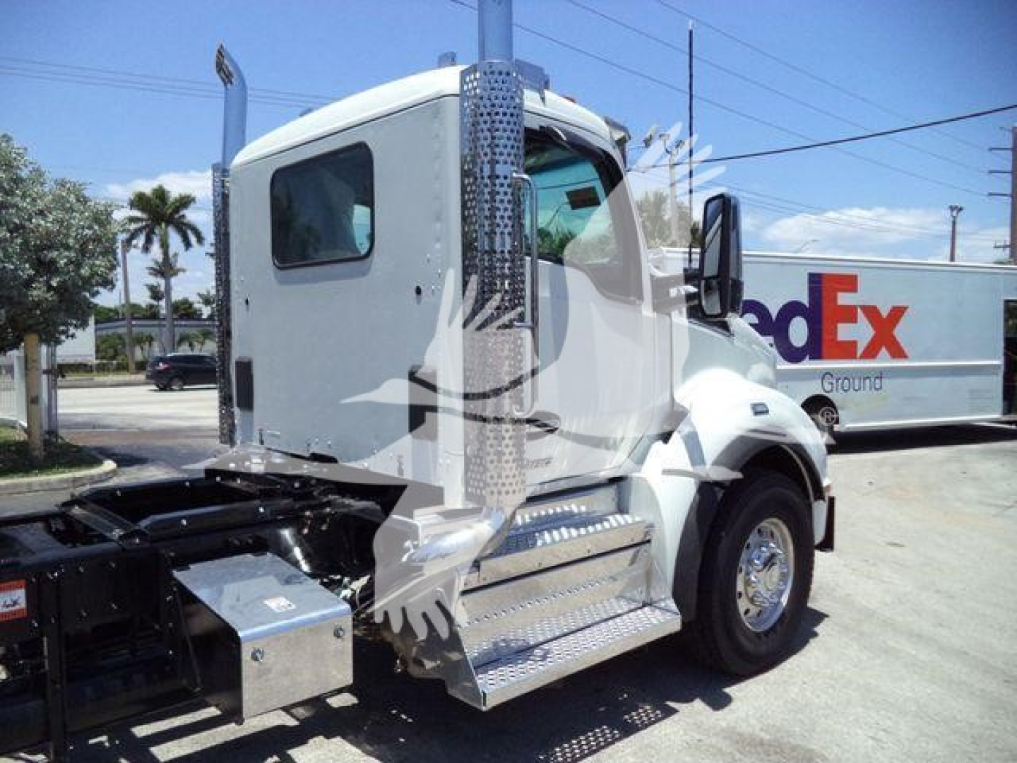 Kenworth T880 truck cab side view with steps and chassis bolts visible in foreground.