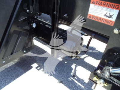 Kenworth T880 chassis area showing hydraulic components and warning label, with roll-back truck equipment and warning stickers visible.