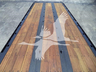 Flatbed truck deck with wooden planks and black steel rails, viewed from above.