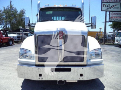 Kenworth T880 front view in white showing grille, bumper, and headlights in a dealership lot.