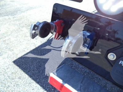 Kenworth T880 rollback truck showing hydraulic hookups and rear bumper area with connectors: red, blue, gray fittings mounted on a glossy black surface.