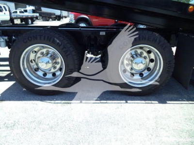 Truck wheel pair on Kenworth T880 rollback, Continental tires with chrome rims, visible undercarriage components.