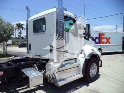 Kenworth T880 truck cab side view with steps and chassis bolts visible in foreground.