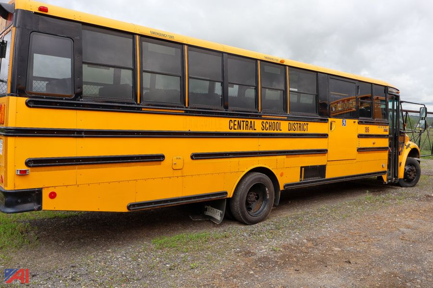 Yellow Freightliner C2 Saf-T-Liner school bus side and rear view showing Central School District lettering and black stripes.