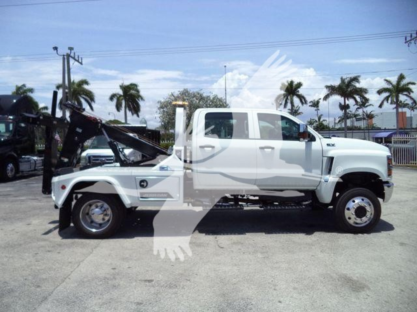 2023 International CV truck with winch, side view showing large dual rear wheels, white cab, and black winch platform. Visible text includes 'Stock Number: J19799FM', 'Category: Winch', 'Type: Trucks', 'NewUsed: New'.