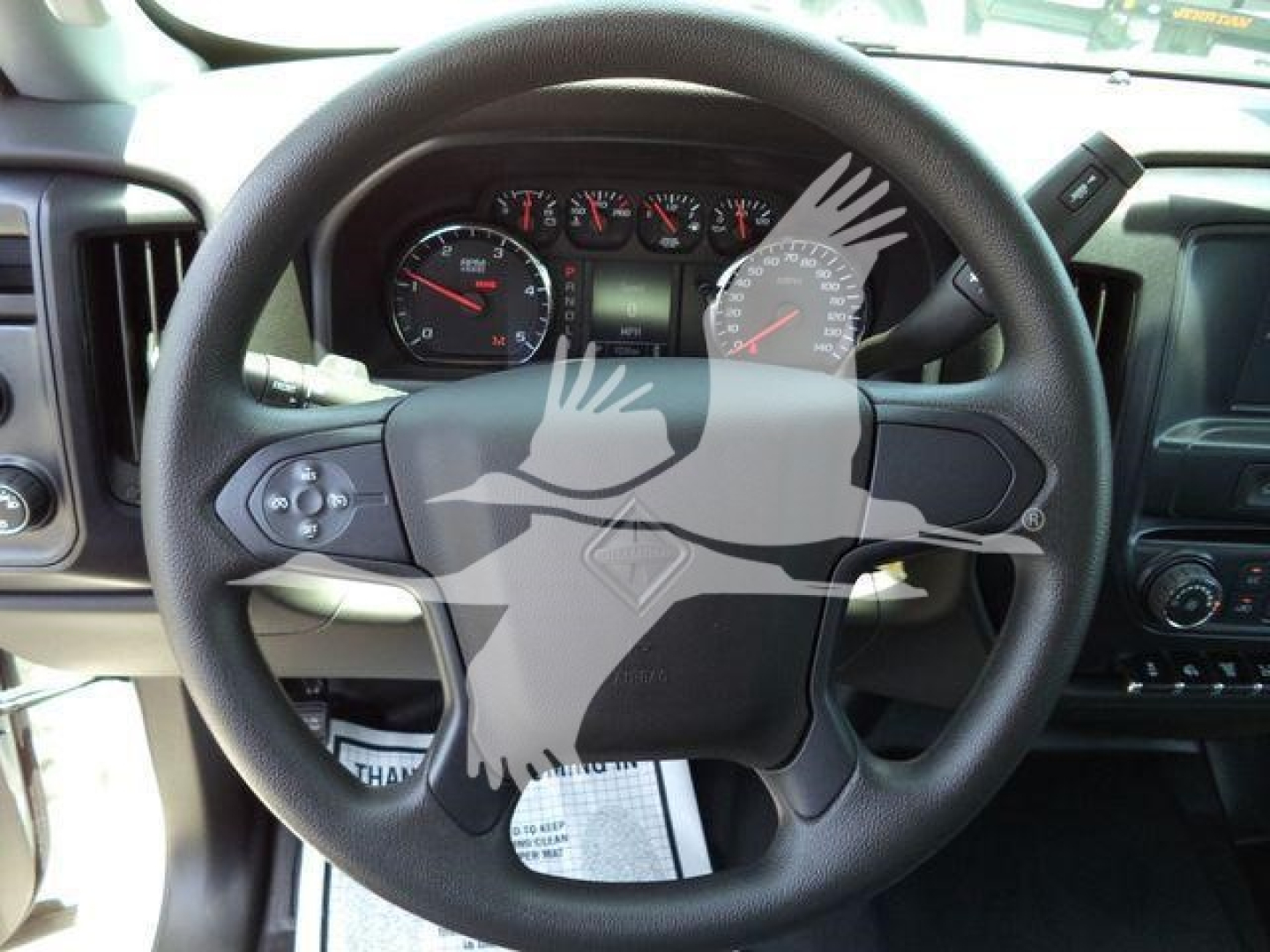 Steering wheel and dashboard of a 2023 International CV truck showing gauge cluster and steering wheel emblem.