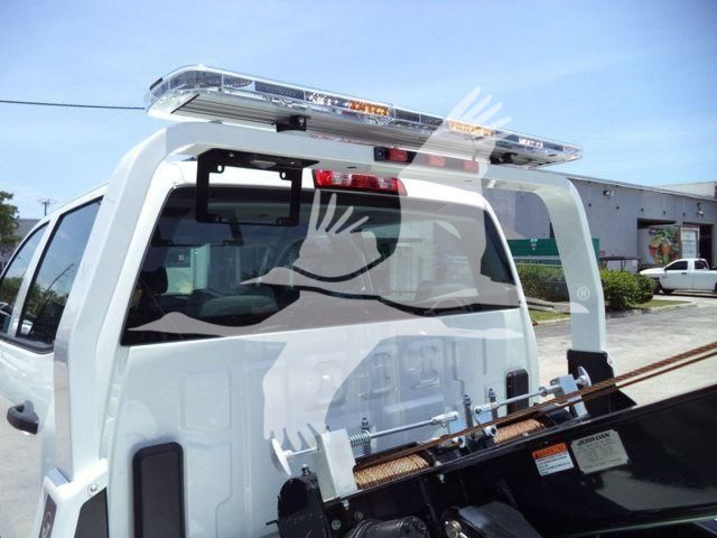 International CV truck rear with winch package and light bar in service window showing spare parts tag