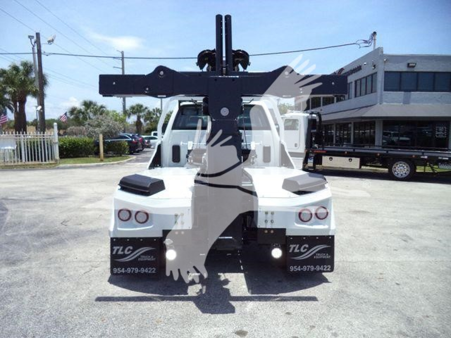 Winch-equipped truck hitch assembly and rear view of a white 2023 International CV with towing apparatus and TLC branding.