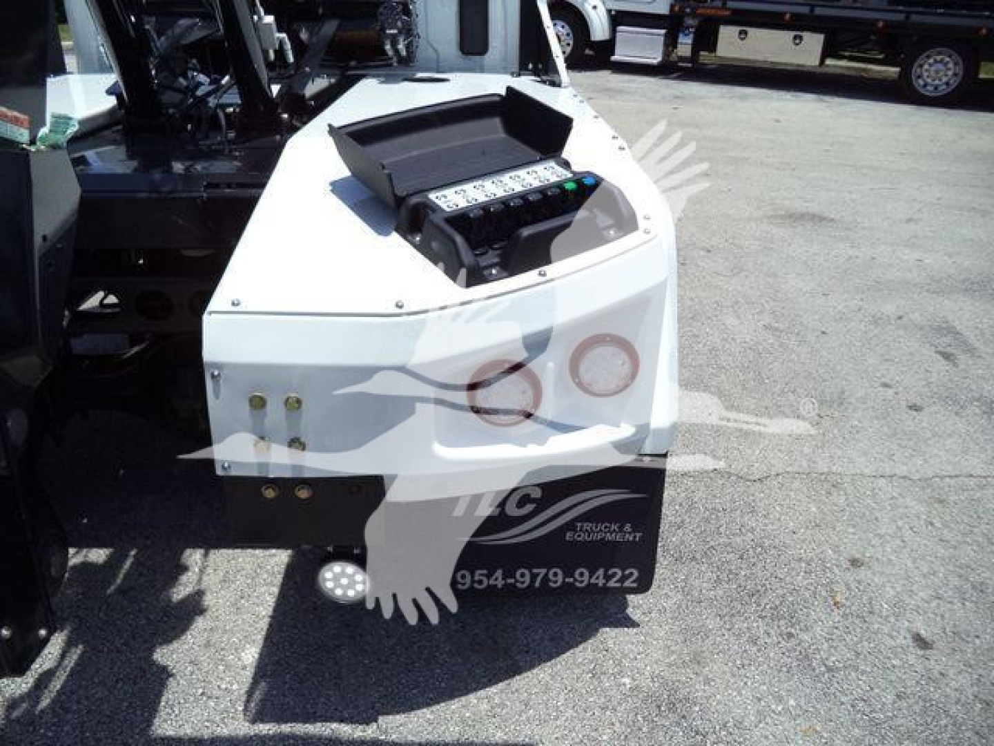 Winch-equipped truck component showing control panel with labeled switches and two circular ports on white housing, view of front-left area.