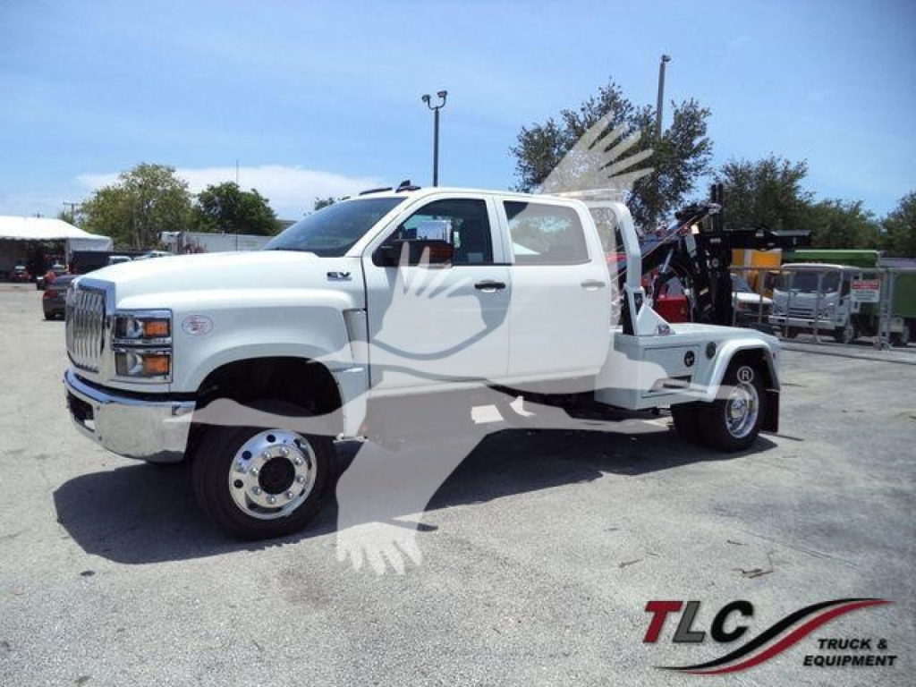 Winch-equipped white 2023 International CV truck viewed from a side angle with extended cab, heavy-duty front tires, and dual rear wheels.