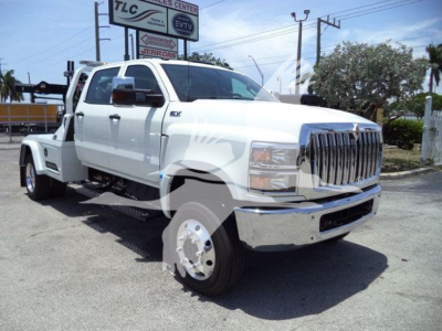 White 2023 International CV truck with dual rear wheels and chrome grille, front view, lift-equipped winch category vehicle.