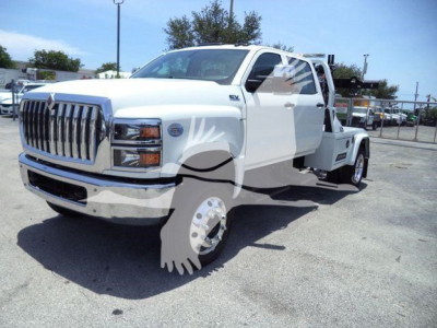Tow truck chassis with extended cab showing front grille and dual rear wheel chrome rims.