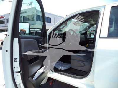 Truck cab interior with front door open, steering wheel visible, documents on seat, and exterior white paint