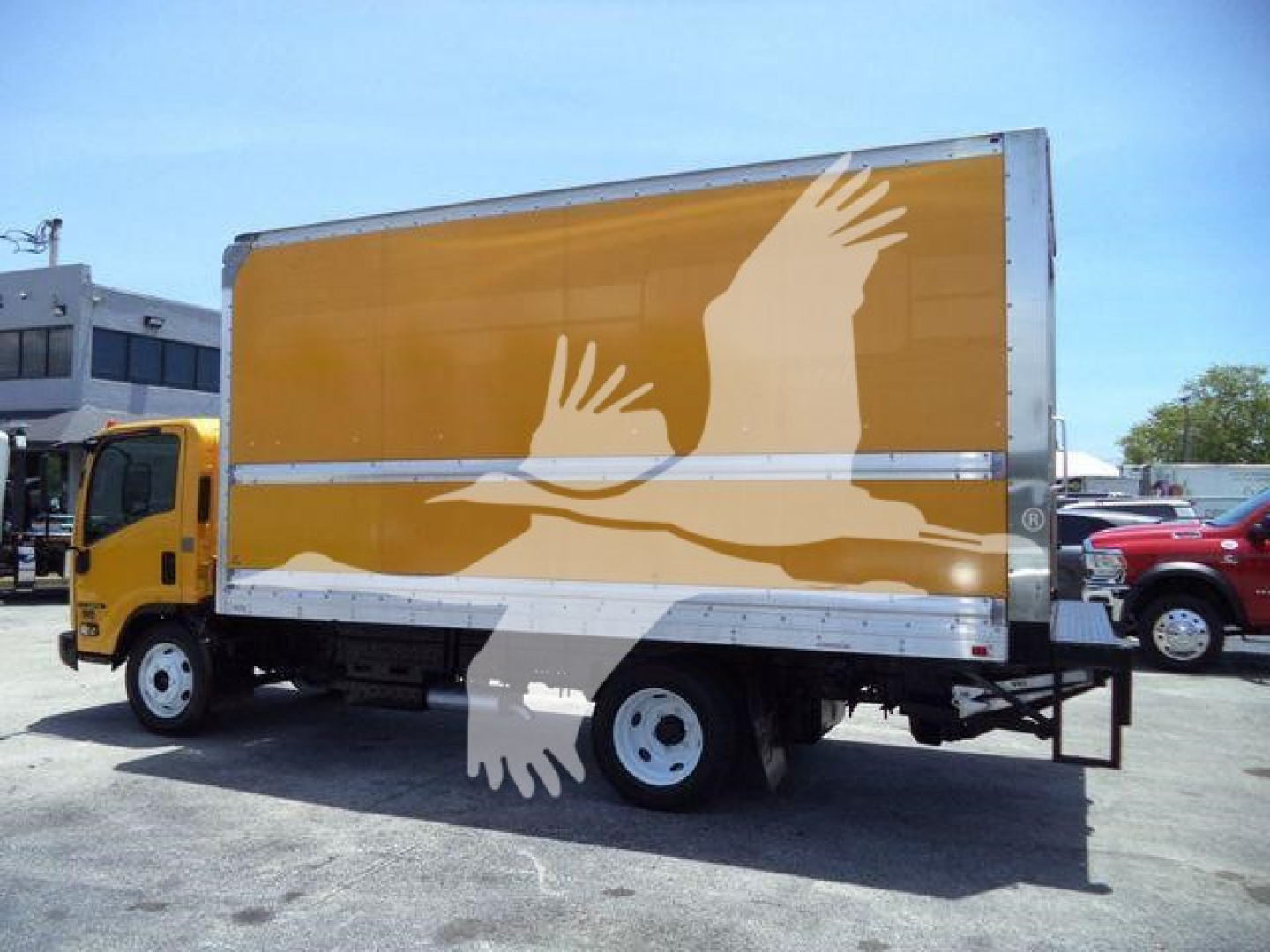 Isuzu NPR HD box truck in profile showing yellow cab and large brown box with white graphics and wheels in side view.
