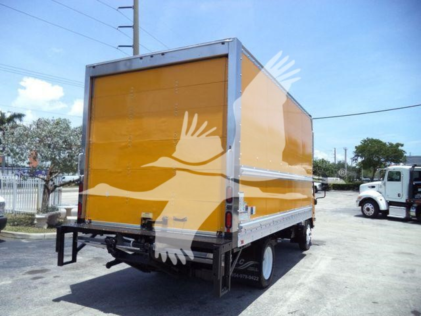 Isuzu NPR-HD box truck back/side view showing yellow cargo box and black undercarriage.