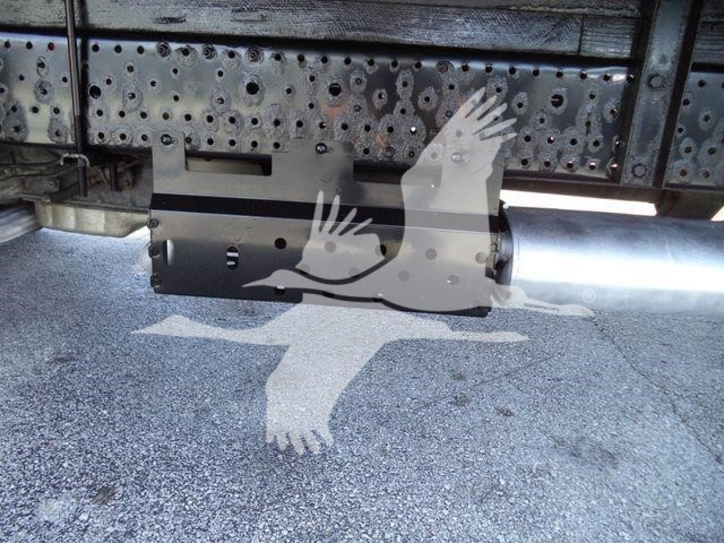 Isuzu NPR HD underside of truck showing exhaust/muffler and rear undercarriage with perforated metal shield.