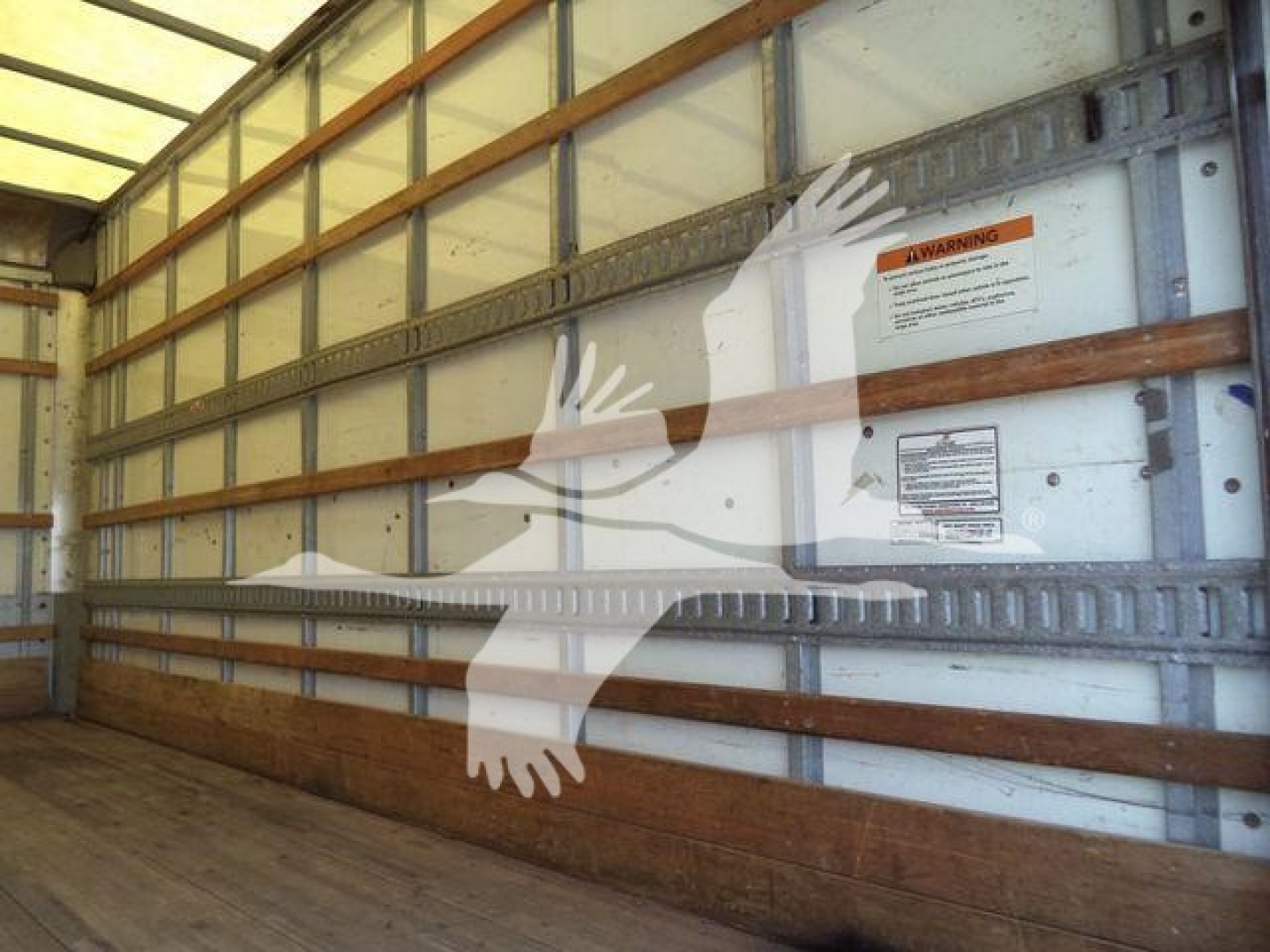 Isuzu NPR-HD box truck interior side wall with warning labels and side rails.