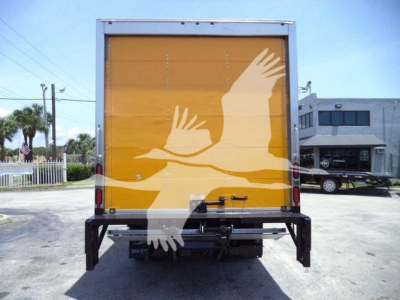 Isuzu NPR HD box truck rear showing yellow cargo door with white dove graphic and black bumper components.