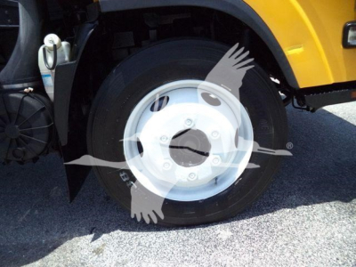 Isuzu NPR HD front wheel and fender with yellow body panel and wheel hub visible