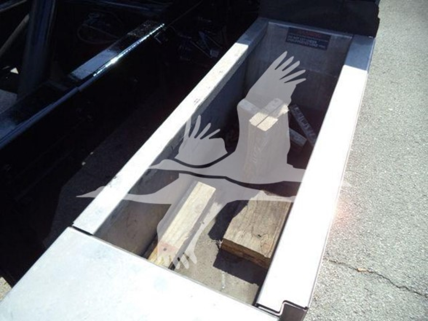 Truck bed with wood blocks and a stenciled graphic of hands forming a bird, visible inside the cargo area of a 2017 Ford F650 rollback truck.