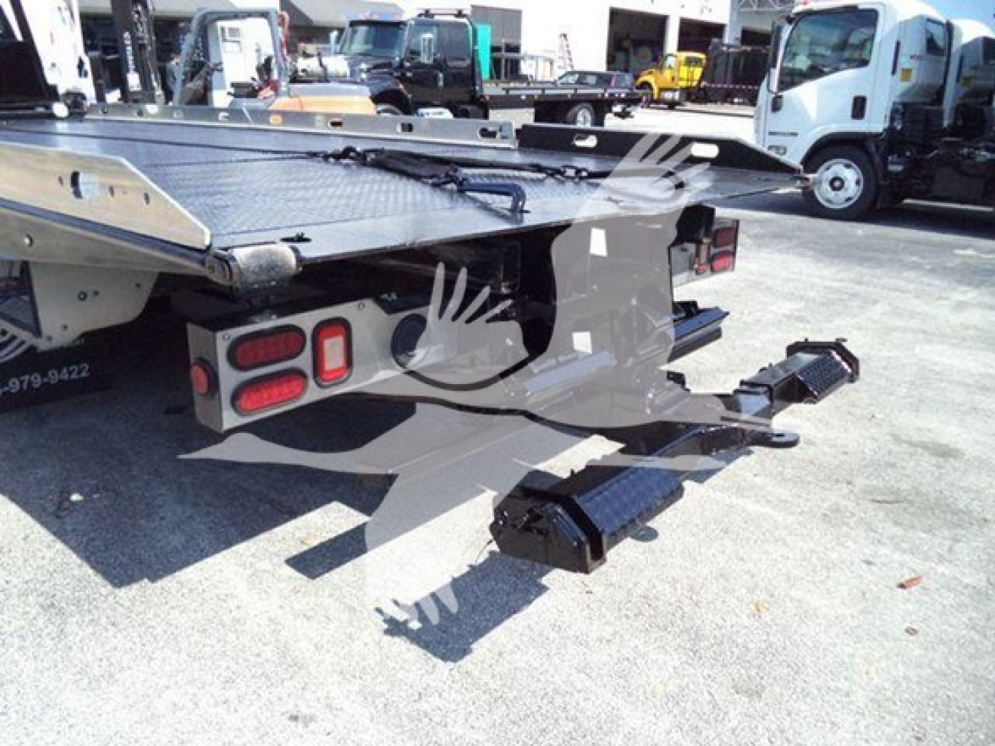 Ford F650 rollback truck hitch and rear platform with step pads and taillights visible.
