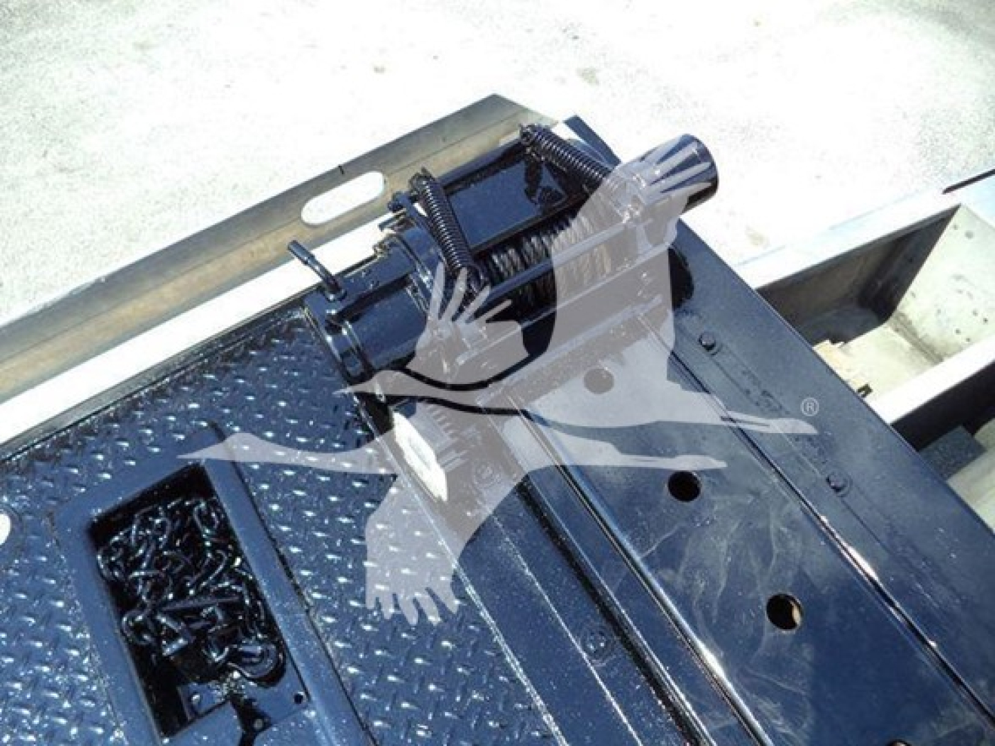 Trucks equipment bay showing hydraulic components and control unit mounted on diamond-plate platform.