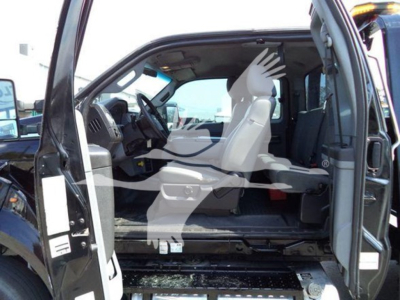 Ford F-650 rollback truck cab interior view with front bench seat and dashboard, driver door open, beige seats, and clear VIN/stock info overlay