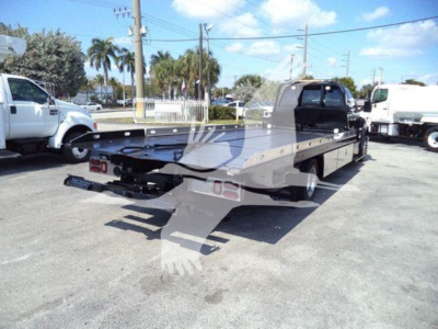 Ford F650 rollback chassis viewed from rear/side showing flatbed and rear towing setup.