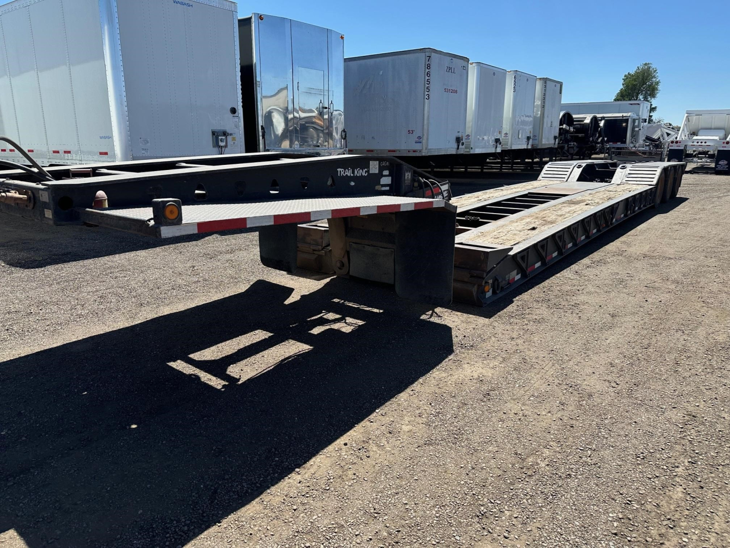 Trailer King lowboy showing 2008 Trail King 50 Ton lowboy with pony motor and 25'5" well, side rails and ramps, in a yard.