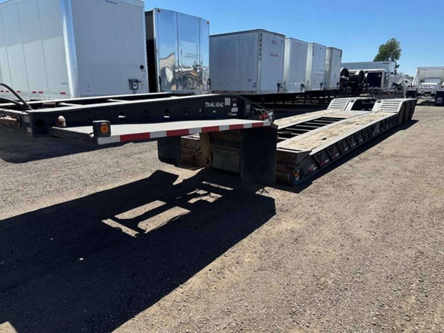 Trailer: 2008 Trail King 50 Ton Lowboy with pony motor, long flatbed with multiple axles, low deck height, black frame, white-red reflective tape, listed as used.