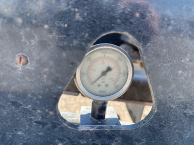 Trailer gauge showing dial inside well area of a 2008 Trail King 50 Ton Lowboy trailer, front view of scale mounted in cutout.