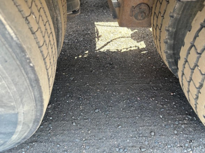 Trailer undercarriage showing dual rear tires and gap between axles on a 50 ton lowboy trailer.