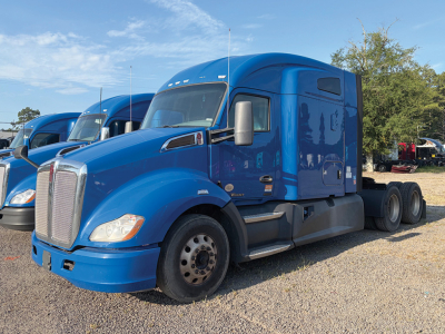 Blue Kenworth T680 daycab tractor in a row of trucks showing front and side, no visible text besides the truck details.