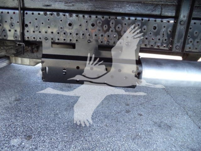 Underbody view of isuzu NPR-HD truck showing a cylindrical fuel tank and metal frame with perforated side panels; watermark of two birds overlapping.